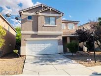 Two-story home featuring neutral stucco and an attached two-car garage at 4905 Morning Falls Ave, Las Vegas, NV 89131