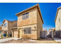 Two-story stucco home featuring a small front yard, attached garage and fenced entrance at 5179 Floralita St, Las Vegas, NV 89122