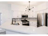 Modern kitchen features stainless steel appliances, white cabinets, and stylish lighting at 5225 W Reno Ave # 105, Las Vegas, NV 89118