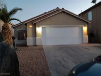 Charming single-story home featuring a well-maintained front yard and attached two-car garage at 5875 Rainbow Bridge Dr, Las Vegas, NV 89142