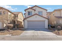 Beige two-story home featuring a two-car garage and low-maintenance desert landscaping at 7452 Wine Creek St, Las Vegas, NV 89139