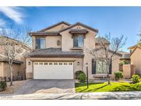 Two-story stucco home features manicured landscaping, a two-car garage, and a welcoming front entrance at 9037 Wolf Dancer Ave, Las Vegas, NV 89143