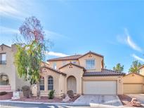 Charming two-story home features stucco siding, a tile roof, and a well-manicured front yard, and a two car garage at 10383 Gwynns Falls St, Las Vegas, NV 89183
