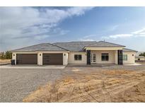 Beautiful single-story home boasts a spacious three-car garage, modern design, and drought-resistant landscaping at 1601 W Calvada Blvd, Pahrump, NV 89048