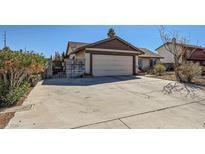 Charming single-story home showcasing a two-car garage, mature landscaping, and a spacious driveway at 2375 Rawhide St, Las Vegas, NV 89119