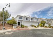 Charming townhome featuring a well-maintained, light gray exterior with a two-car garage and manicured landscaping at 2405 Esteem Ridge Dr, Henderson, NV 89052