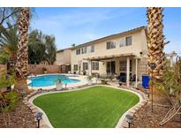 Expansive backyard with lush lawn, pool, and covered patio area ideal for outdoor relaxation and entertaining at 820 Sandhill Sage St, Henderson, NV 89052