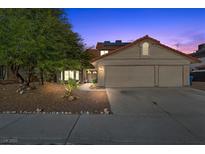 Inviting two-story home featuring a red tile roof, well-maintained landscaping, and an attached two-car garage at 8912 Dio Guardi Dr, Las Vegas, NV 89117
