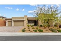 Beautiful single-story home featuring neutral stucco, stone accents, desert landscaping, and an attached three car garage at 10016 Copper Edge Rd, Las Vegas, NV 89148