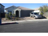 Charming single-story home featuring a well-kept yard and a paved driveway with a parked car at 1421 Deep Valley Ave, North Las Vegas, NV 89084