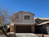 Two-story home featuring a neutral color scheme, stone accents, and an attached two-car garage at 2037 Houdini St, Henderson, NV 89002