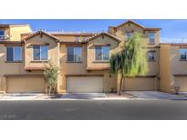 Attractive townhomes featuring attached garages and neutral-colored exteriors in a well-maintained neighborhood at 4542 Townwall St, Las Vegas, NV 89115