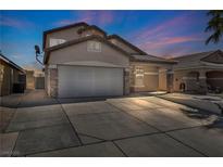 Two-story home with a wide driveway and two-car garage, set against a colorful twilight sky at 7308 Alpine Ridge St, Las Vegas, NV 89131