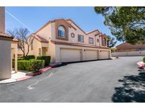 Inviting townhome featuring a three-car garage, desert landscaping, and a charming tiled roof at 8301 Boseck Dr # 215, Las Vegas, NV 89145