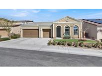 Charming single-story home featuring a three-car garage, arched windows, and a well-maintained front yard at 920 Claystone Ridge Ave, North Las Vegas, NV 89084