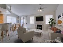 Bright living room featuring a fireplace, ceiling fan, and adjacent dining area perfect for entertaining at 205 Crown Imperial St, Henderson, NV 89074