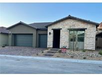 New single-story home with a stone facade and two-car garage with brick paver driveway at 22 Barrio Alto Ct, Henderson, NV 89011