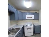 Cozy kitchen featuring blue cabinets, white appliances, and ample counter space at 304 Orland St # 39, Las Vegas, NV 89107