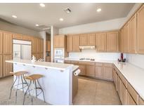 Bright kitchen featuring a large island with barstool seating, modern appliances, and ample cabinet space at 1 Ibis Ct, Henderson, NV 89052
