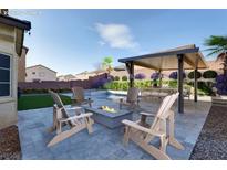 Backyard view with custom firepit, outdoor kitchen and desert landscaping at 1016 Tropic Wind Ave, North Las Vegas, NV 89081
