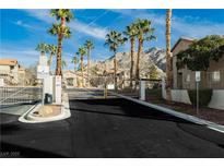 Gated community entrance with palm trees and mountain views in the background under a clear blue sky at 2110 Los Feliz St # 2037, Las Vegas, NV 89156