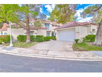 Charming home featuring a red tile roof, stucco siding, well-manicured landscaping, and an attached two-car garage at 6925 Emerald Springs Ln, Las Vegas, NV 89113