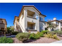 Well-maintained condo complex featuring stucco siding, landscaped grounds, and stairs to unit at 8501 W University Ave # 2020, Las Vegas, NV 89147