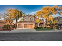 Charming two-story home featuring a three-car garage, well-manicured lawn and mature trees at 2204 Ambermill Ct, Henderson, NV 89052