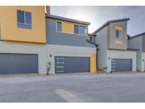 Modern townhome showcases a gray and yellow exterior and a dark gray garage door at 3551 Via Tizzoni St, Henderson, NV 89044