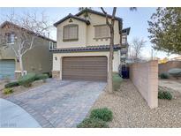 Two-story home with a two-car garage, a well maintained yard and a brick driveway at 6679 Salt Pond Bay St, Las Vegas, NV 89149