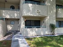 Condominium with stucco siding and light blue rails for the balconies with an exterior side door entrance at 840 N Sloan Ln # 102, Las Vegas, NV 89110