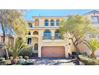 Charming two-story home with desert landscaping, a balcony, arched windows, and a terracotta-colored tile roof at 10716 Shasta Glow Ct, Henderson, NV 89052