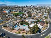 Expansive aerial view featuring lush neighborhood, sparkling community pool, and a breathtaking skyline backdrop at 1409 Bonita Ave, Las Vegas, NV 89104