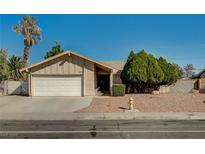 Charming single-story home featuring a well-maintained front yard, mature trees, and an attached two-car garage at 2974 Lindell Rd, Las Vegas, NV 89146