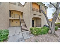 A close exterior view of a two-story condo building with access stairs and partial landscaping at 7885 W Flamingo Rd # 1016, Las Vegas, NV 89147