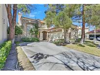 Charming two-story home featuring a spacious driveway and lush landscaping at 8460 Carmel Ridge Ct, Las Vegas, NV 89113