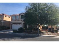 Charming two-story home with a well-manicured lawn, large tree, and a spacious two-car garage at 8494 Langhorne Creek St, Las Vegas, NV 89139