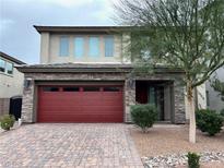 Charming two-story home featuring a red garage door and stone accents at 11260 Burning River St, Las Vegas, NV 89183