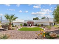 Expansive single story home with white tile roof and circular entrance with mature desert landscaping at 3585 Tobias Ln, Las Vegas, NV 89120