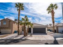 Charming single-story home featuring desert landscaping, tile roof, palm trees, and a two-car garage at 6505 Moon Roses Ct, Las Vegas, NV 89108