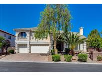 Charming two-story home featuring a three-car garage, landscaped yard and a brick-paved driveway at 7623 Calm Passage Ct, Las Vegas, NV 89139