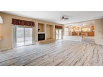 Bright living room features fireplace, sliding glass doors to backyard, and luxury vinyl plank flooring at 7623 Calm Passage Ct, Las Vegas, NV 89139