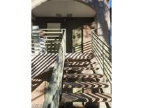 Apartment entrance featuring an outdoor staircase with metal railings leading to a secure entry door and unit number at 7730 Secret Shore Dr # 207, Las Vegas, NV 89128