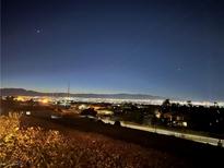 Night panoramic view of the city lights with mountains on the horizon, offering a captivating urban landscape at 2503 Kaymin Ridge Rd, Henderson, NV 89052