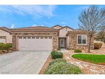Charming single-story home with stone accents, a well-manicured lawn, and a two-car garage on a sunny day at 2535 Jada Dr, Henderson, NV 89044