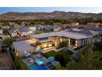 Stunning aerial view of a modern home with a pool, jacuzzi, and mountain views at 3452 Spanish Winds Ct, Las Vegas, NV 89141
