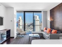 Bright living room featuring a modern sofa, expansive windows with a city view, and sleek furnishings at 4381 W Flamingo Rd # 2504, Las Vegas, NV 89103