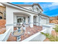 Inviting front porch with brick pavers, comfortable seating, and a charming water fountain feature at 511 Beaconwood St, Henderson, NV 89052