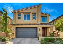 Tan two-story home featuring a well-manicured lawn and a gray garage door at 2313 Mundare Dr, Henderson, NV 89002