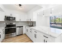 Updated kitchen featuring white cabinetry, stainless steel appliances, and island with stone countertop at 3930 University Center Dr # 101, Las Vegas, NV 89119
